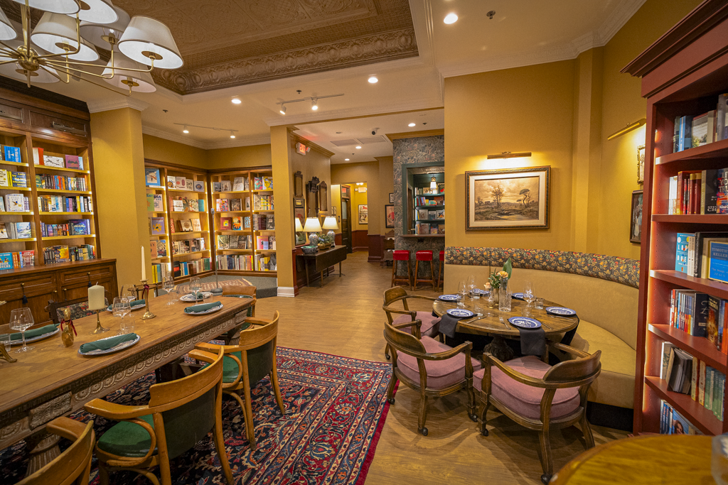 Sage & Scrolls bookstore — curated shelves, communal table, and warm reading light